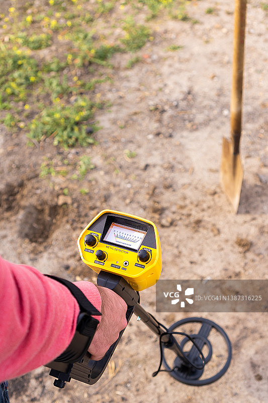 在乡间用金属探测器和铲子寻找物品特写，顶部留白图片素材