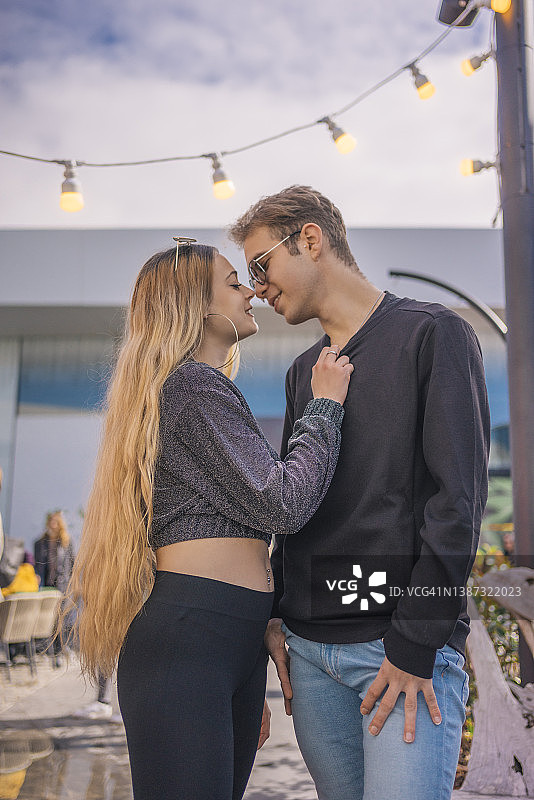 情侣在狂欢节的灯光下即将亲吻图片素材