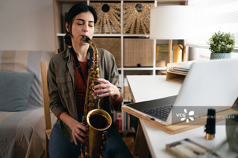 专注的女人在学习萨克斯图片素材