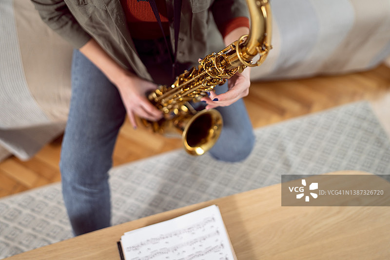一位身份不明的女音乐家演奏萨克斯管的高角度视图图片素材