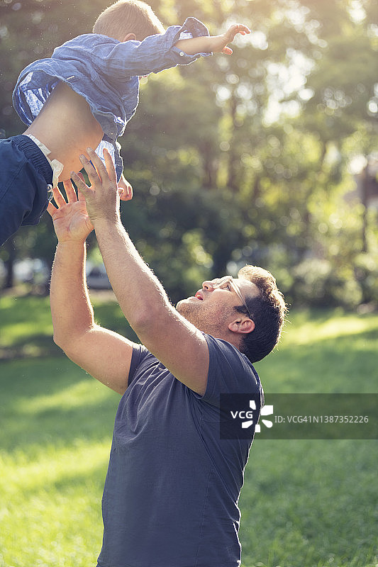 父子在阳光下户外玩耍的肖像图片素材