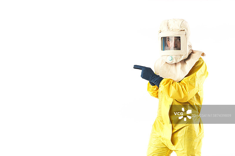 身穿核防护服和防污染头盔的技术人员，指向一侧，留有复制空间，白色背景，核能与疫情概念图片素材