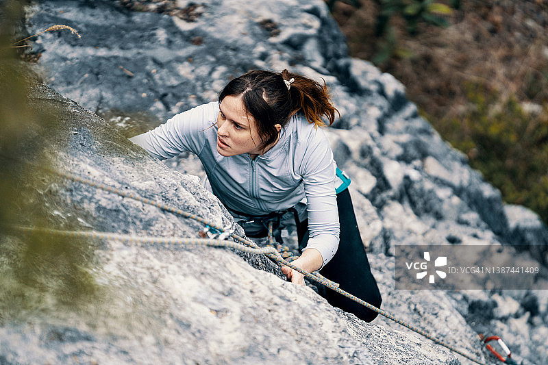 中年妇女在户外攀岩墙上攀岩图片素材