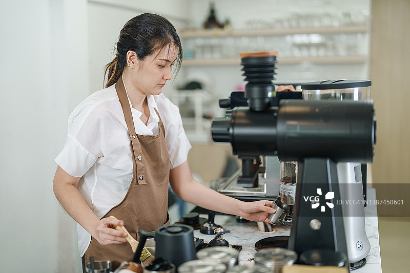 亚洲女人在咖啡馆制作咖啡，咖啡师正在准备咖啡饮品图片素材