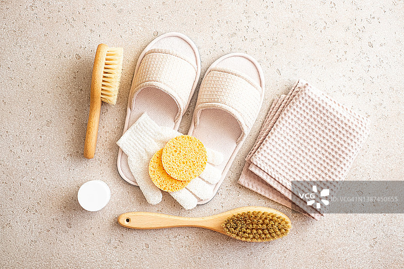 木制干性皮肤身体刷、竹制牙刷、发刷、清洁海绵、拖鞋、清洁手套特写，混凝土背景，俯视图。家庭水疗，平铺。零浪费理念。物品归类理念图片素材