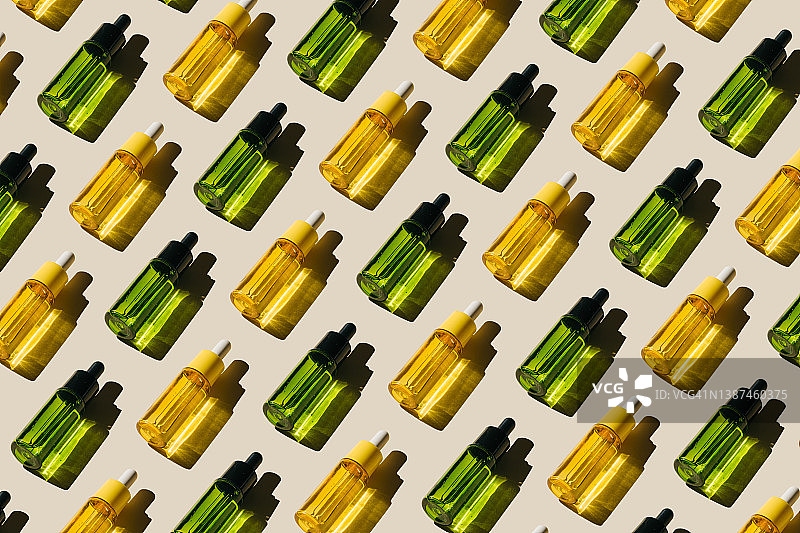 米色背景上的化妆品液体玻璃瓶图案。含肽、神经酰胺、透明质酸凝胶、聚谷氨酸、精油、CBD、视黄醇、胶原蛋白的化妆品。多任务美容。平铺，顶视图图片素材