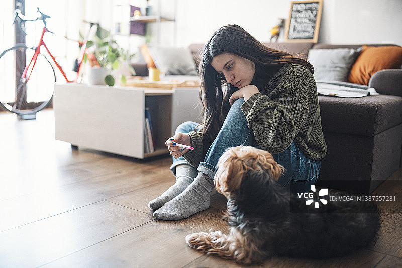 手持验孕棒的悲伤女人图片素材