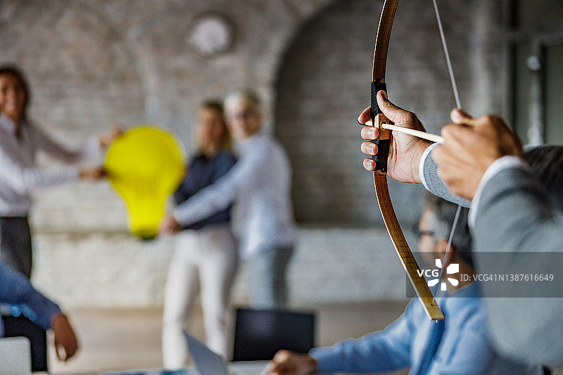 办公室里拿着弓箭的商人特写，无法辨认图片素材
