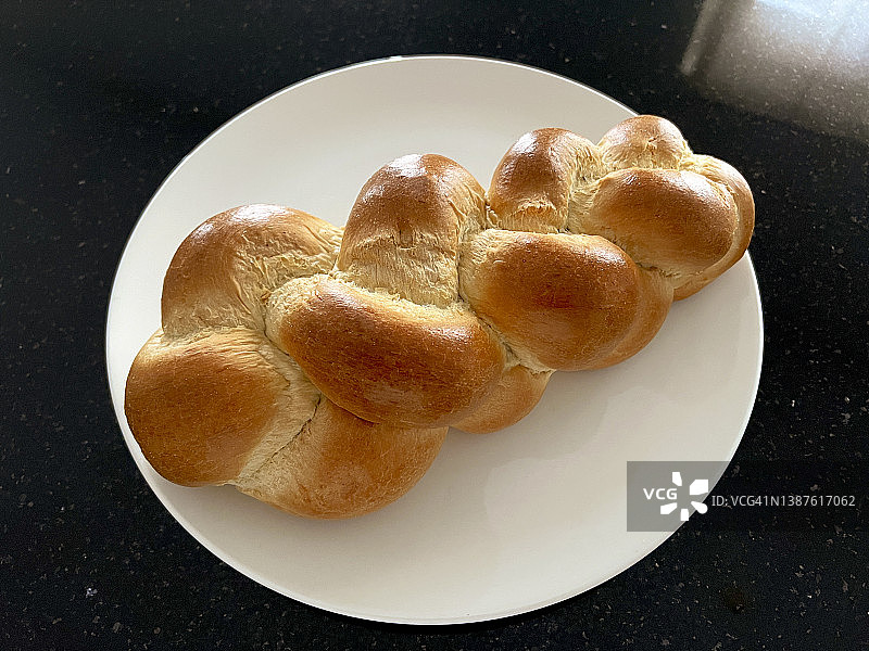 白色盘子里辫子黄油面包的特写图片素材
