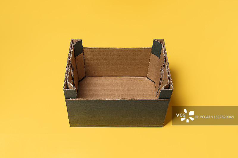 黄色背景上的空纸板箱图片素材