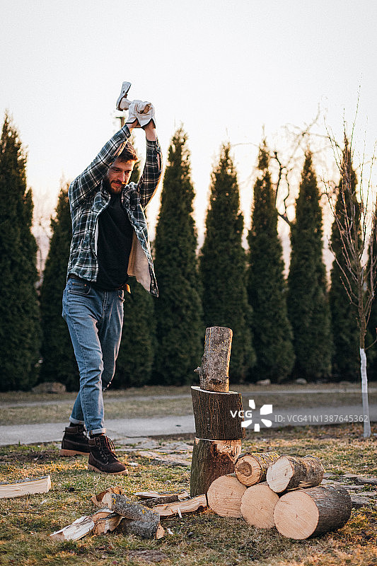 男人在乡村用斧头砍柴图片素材