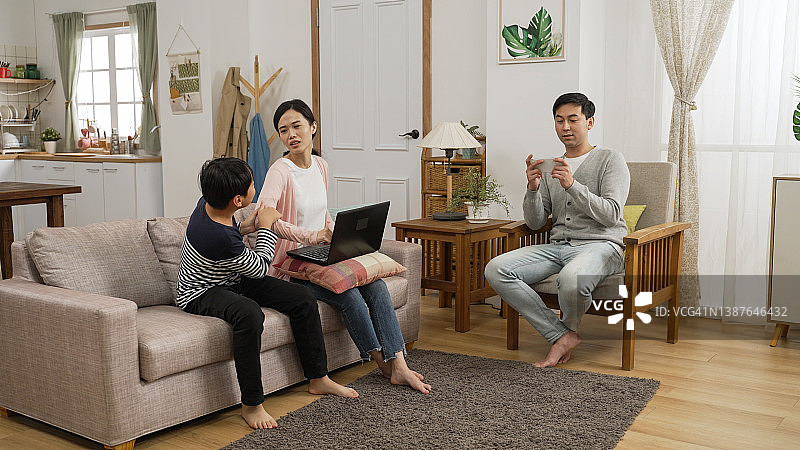 亚洲妈妈因丈夫懒惰和儿子吵闹而感到沮丧图片素材