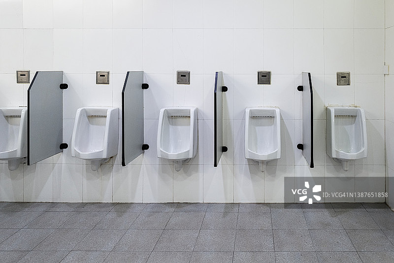 一排男用小便池的正面图图片素材