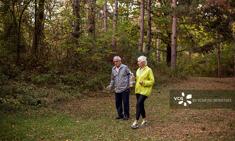 老年夫妇在森林里慢跑图片素材