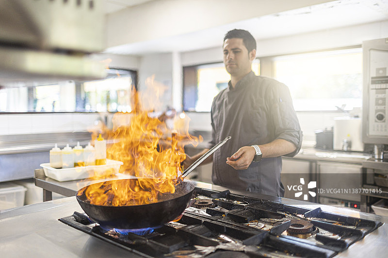厨师在火焰锅中烹饪食物图片素材