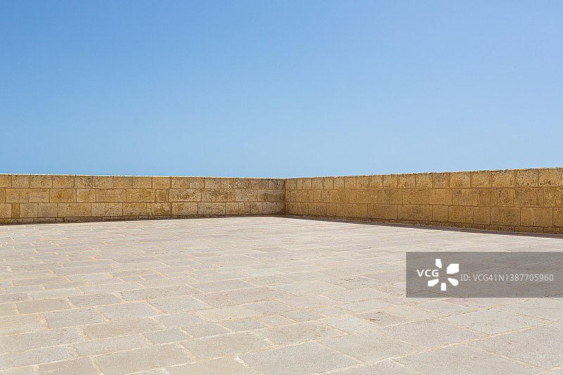 空旷的庭院和石墙角落与铺路石及蔚蓝的天空图片素材