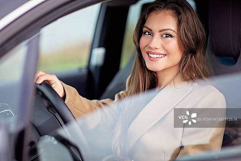 年轻女子驾驶新车的肖像图片素材