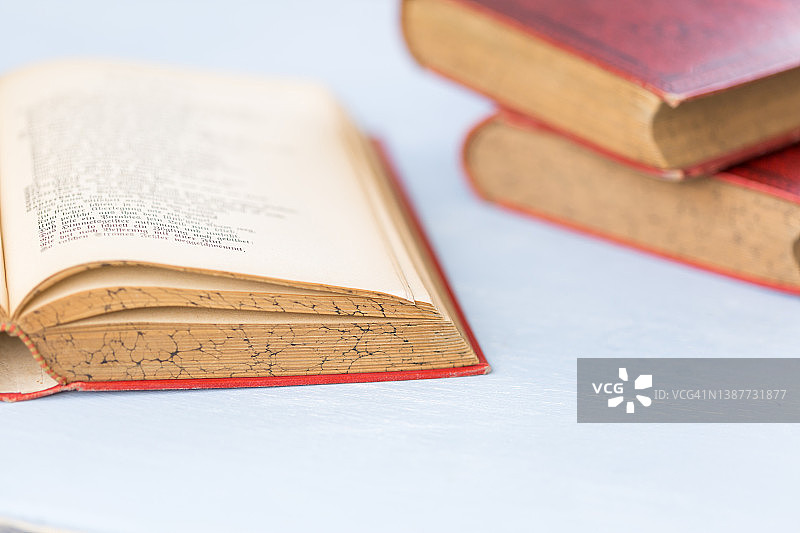 白色蓝色背景上打开的红色精装旧书图片素材