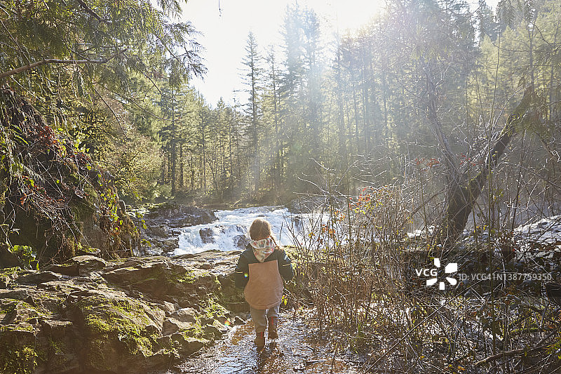 远处凝视瀑布的幼儿图片素材