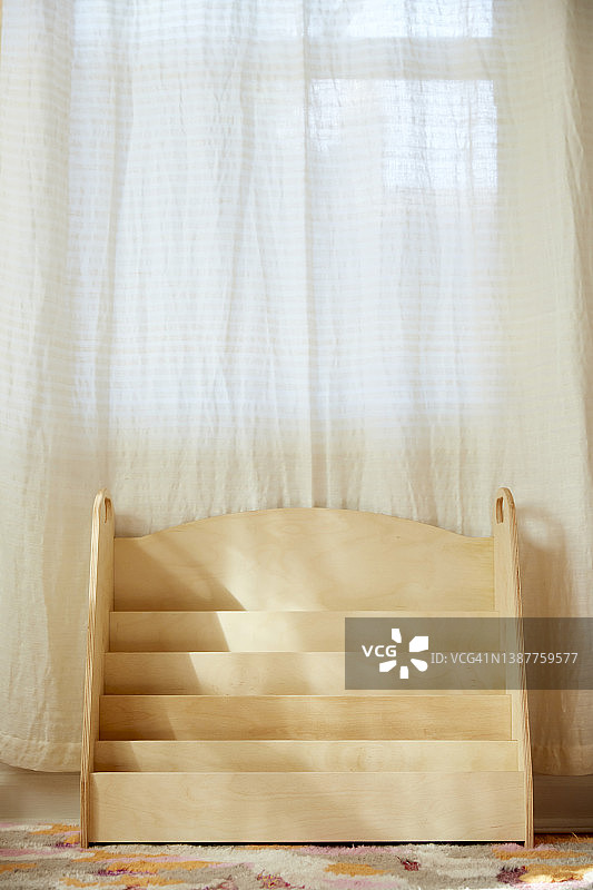 明亮儿童房内的天然木制书架图片素材