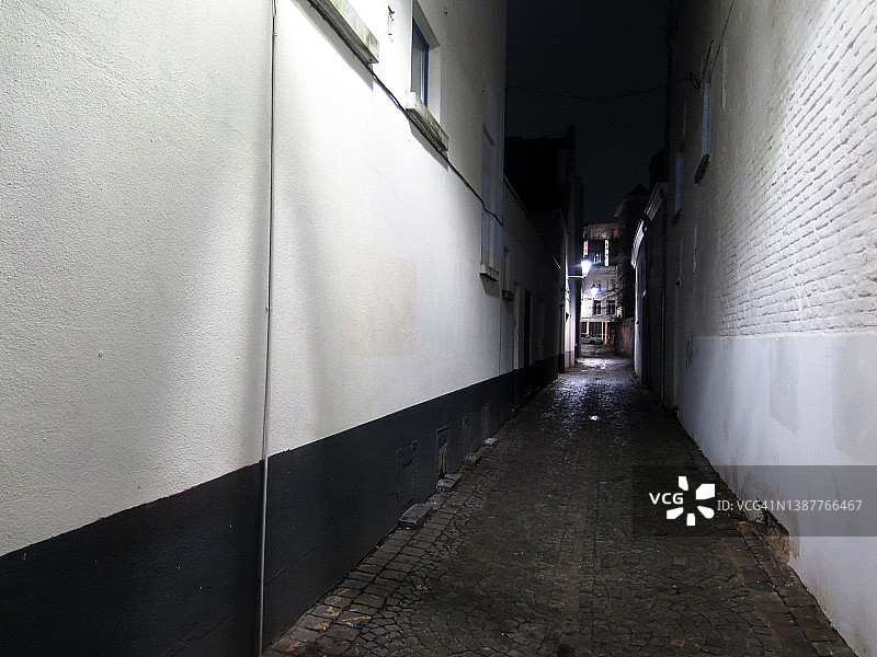 布鲁塞尔夜晚的鹅卵石小巷和白色墙壁图片素材