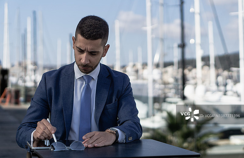 穿蓝色西装年轻男人露台使用平板游艇背景图片素材