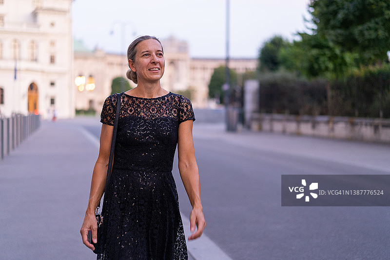 身穿黑色连衣裙走过维也纳市的女人图片素材