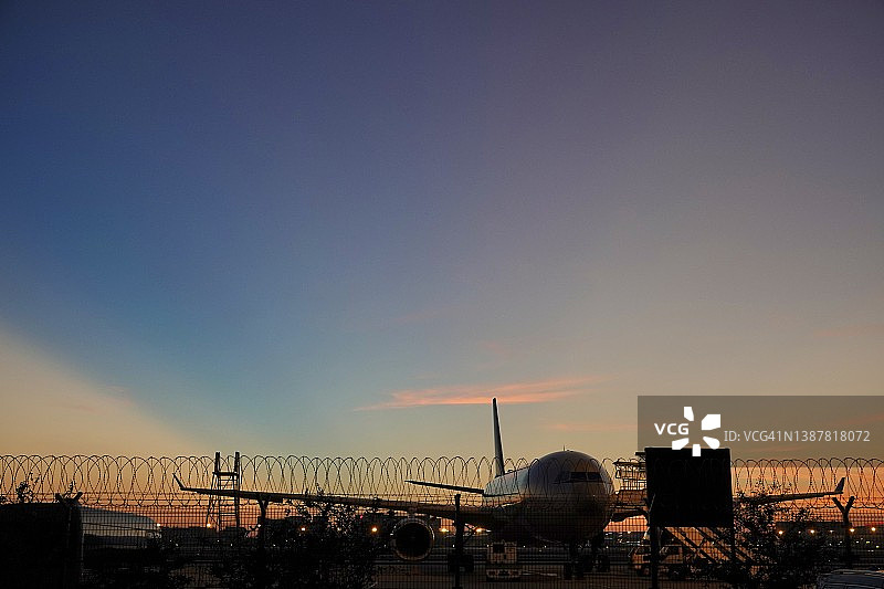 傍晚日落时分停在机场的飞机图片素材