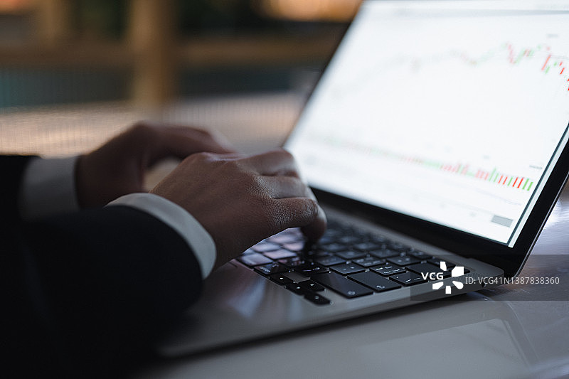 在电脑键盘上显示股票图表的手图片素材