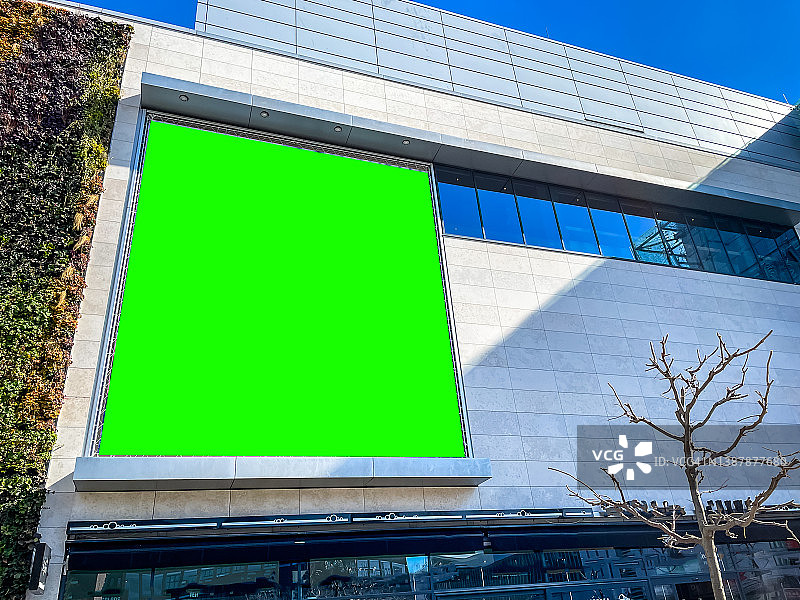 市中心购物中心、火车站或机场的大型专业绿幕色键营销广告牌，面向顾客、购物者、通勤者和游客图片素材