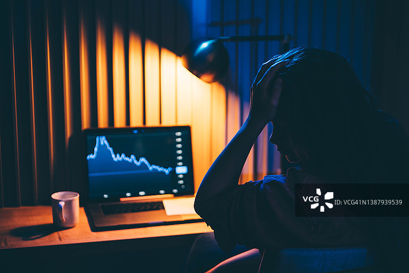 女商人晚上在家看笔记本电脑上的图表图片素材