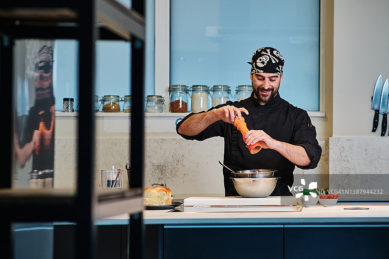 男人在厨房研磨胡椒粉图片素材