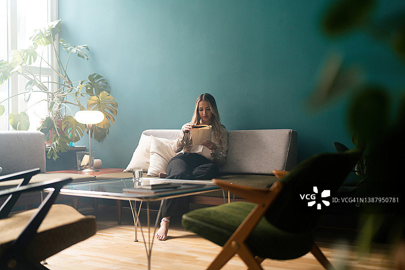 女人在沙发上读书图片素材