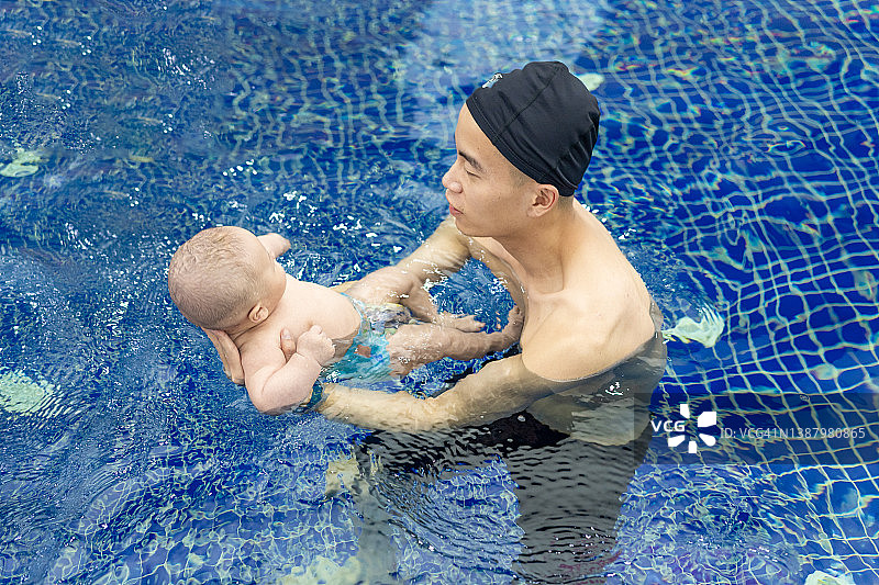 年轻的亚洲父亲和宝宝一起游泳图片素材