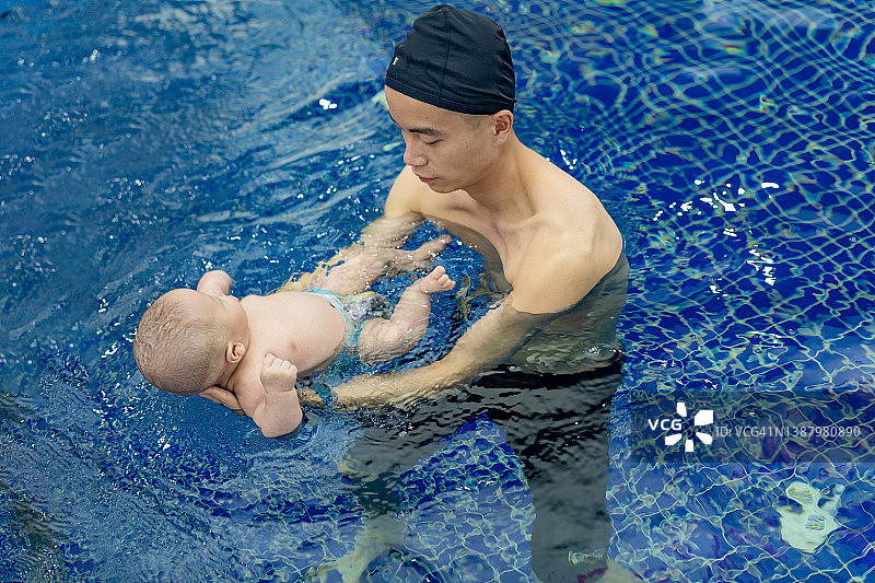 年轻的亚洲父亲和宝宝一起游泳图片素材
