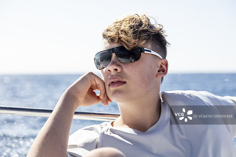 坐在摩托艇上享受假期的青少年男孩图片素材