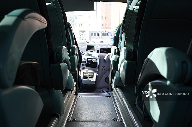 带纺织内饰的公交车座椅，排排整齐，配有皮革扶手和安全带，现代舒适的旅游交通内饰。图片素材