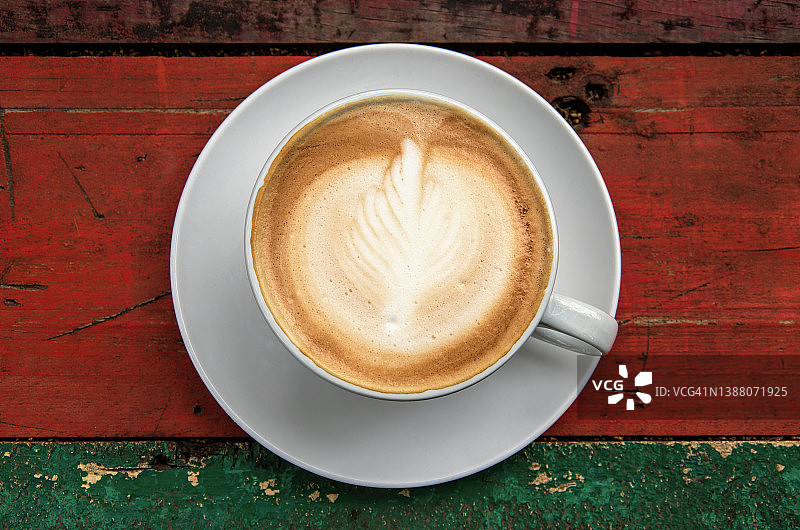 白色杯子里的白咖啡，置于回收木制咖啡桌上图片素材