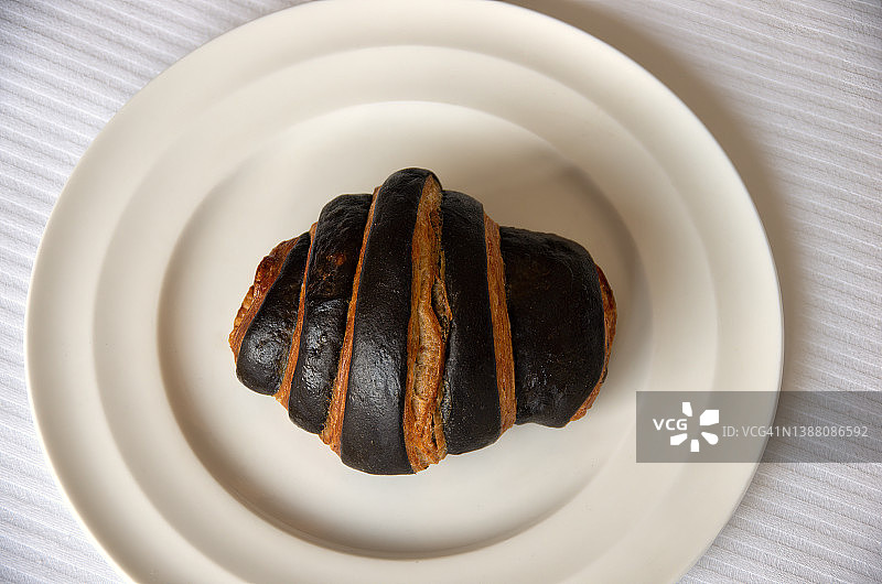 白色圆盘上的条纹巧克力羊角面包图片素材