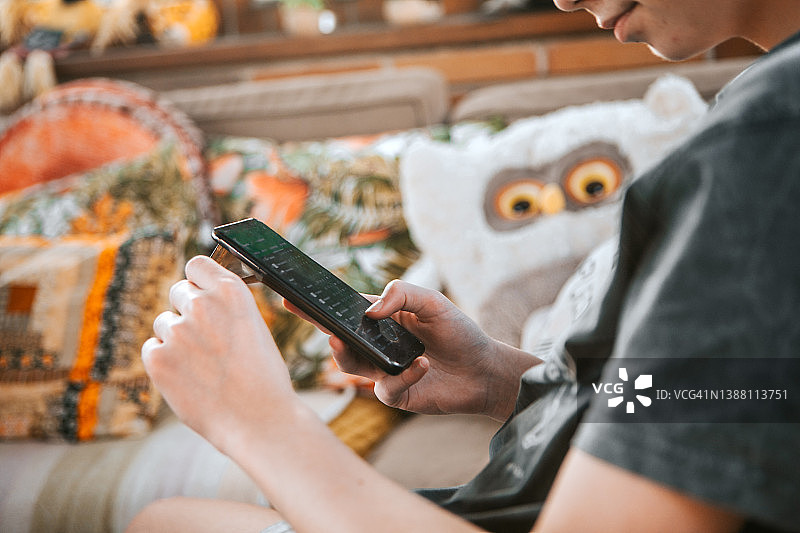 在家用手机发短信的西班牙裔青少年男子图片素材