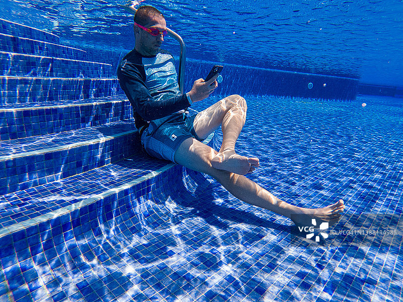 沉迷于社交网络的男人：在水下使用手机图片素材