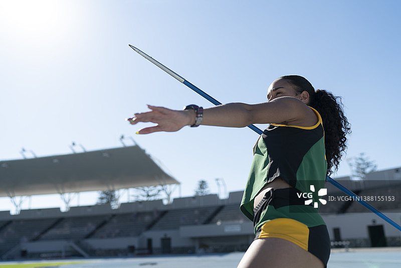 专注的田径女运动员在体育场投掷标枪图片素材