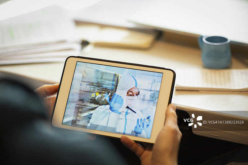男人在平板电脑上看科学家用移液器做实验图片素材