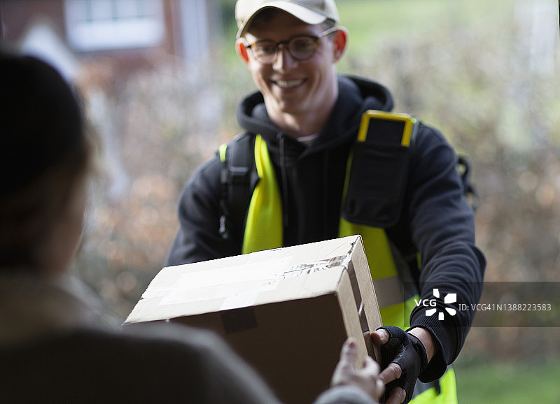 友好的男快递员送货上门图片素材