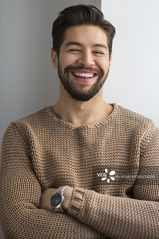 在家中双手交叉站立的英俊男子肖像图片素材