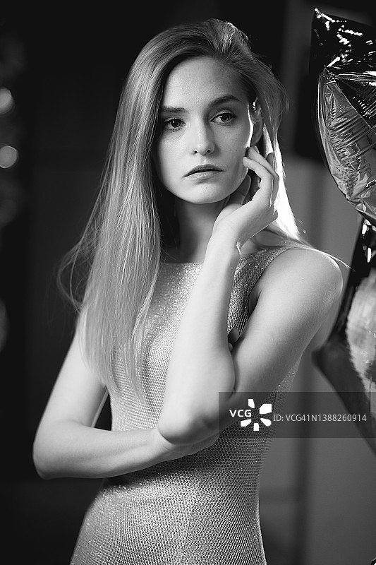 漂亮的女人在室内穿着豪华服装的女性美妆肖像。 金发女孩摆姿势，穿着考究的专业模特，化着盛装。 黑白特写摄影图片素材