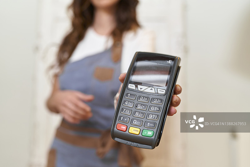 特写：女子在厨房用信用卡支付图片素材