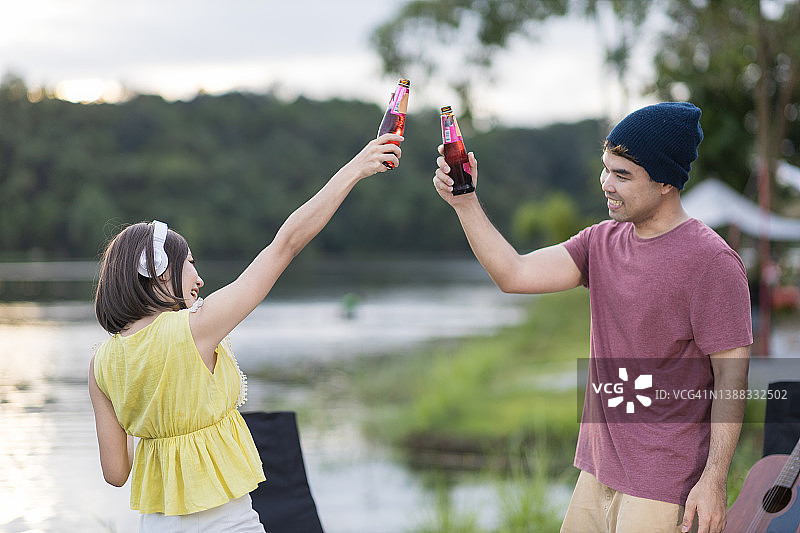 亚洲夫妇享受露营时一起喝酒的乐趣图片素材
