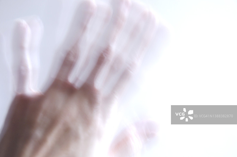 白色背景上女性手部的模糊影像，精神疾病概念图片素材