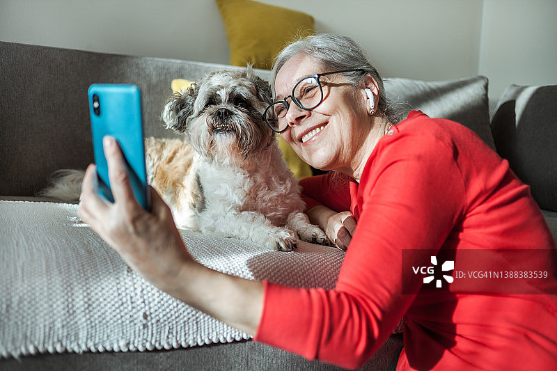 老年妇女在家与爱犬自拍图片素材